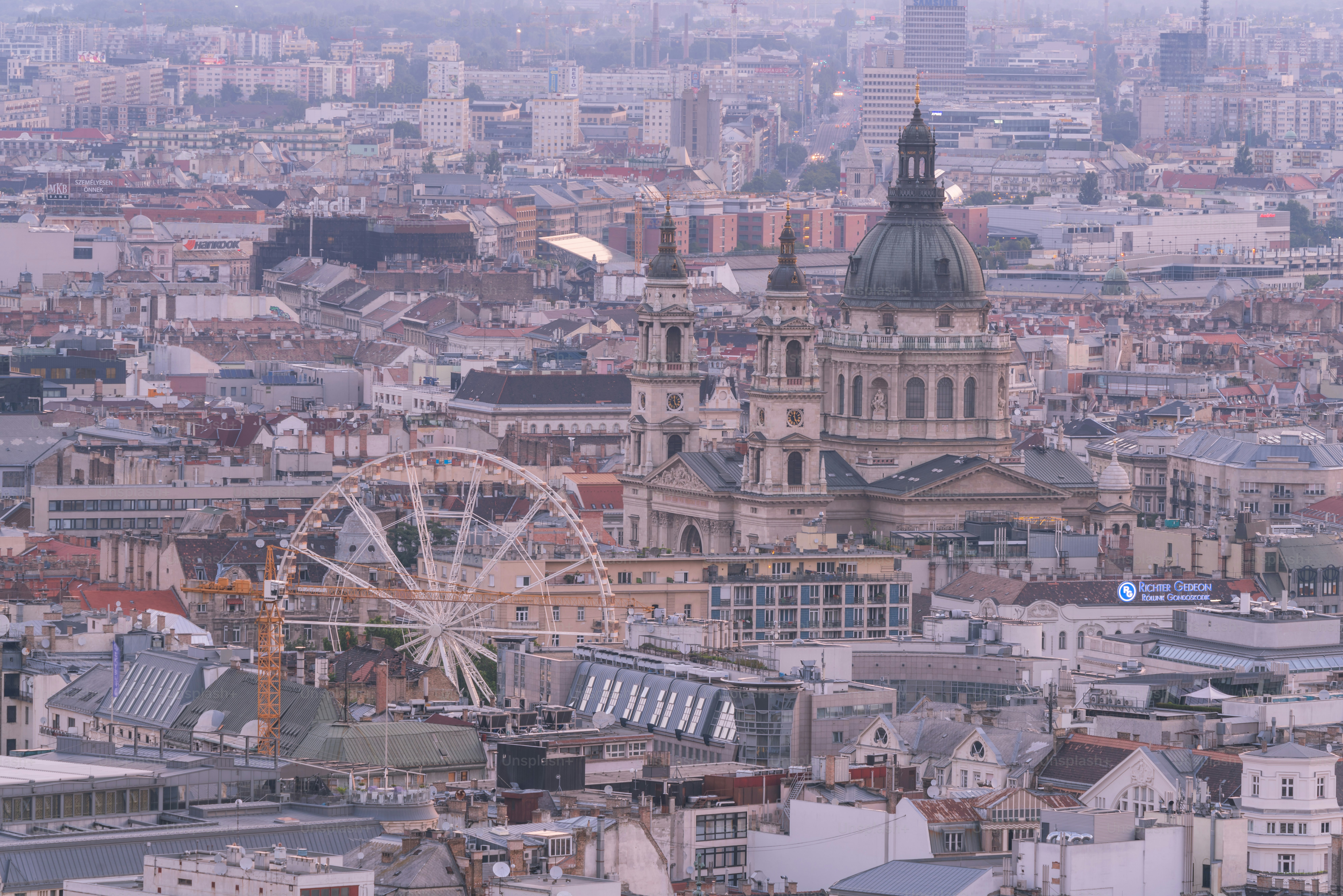 Blick auf eine Stadt mit einem Riesenrad im Vordergrund