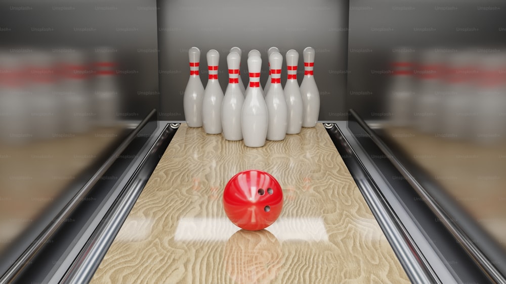 a bowling alley with a red bowling ball and pins