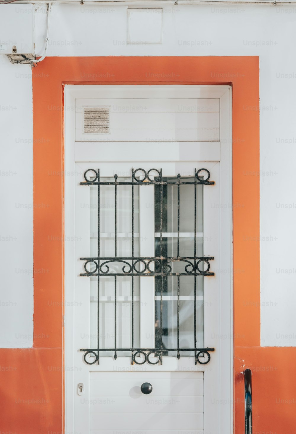 una puerta blanca con barras de hierro forjado