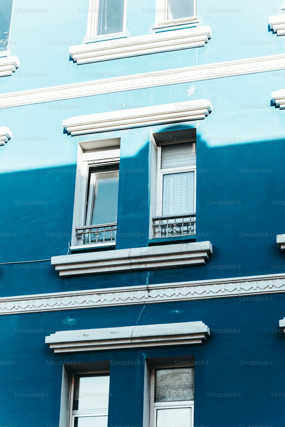 Un edificio azul con dos ventanas y un balcón