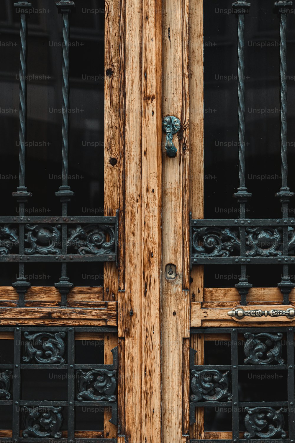 a close up of a wooden door with iron bars