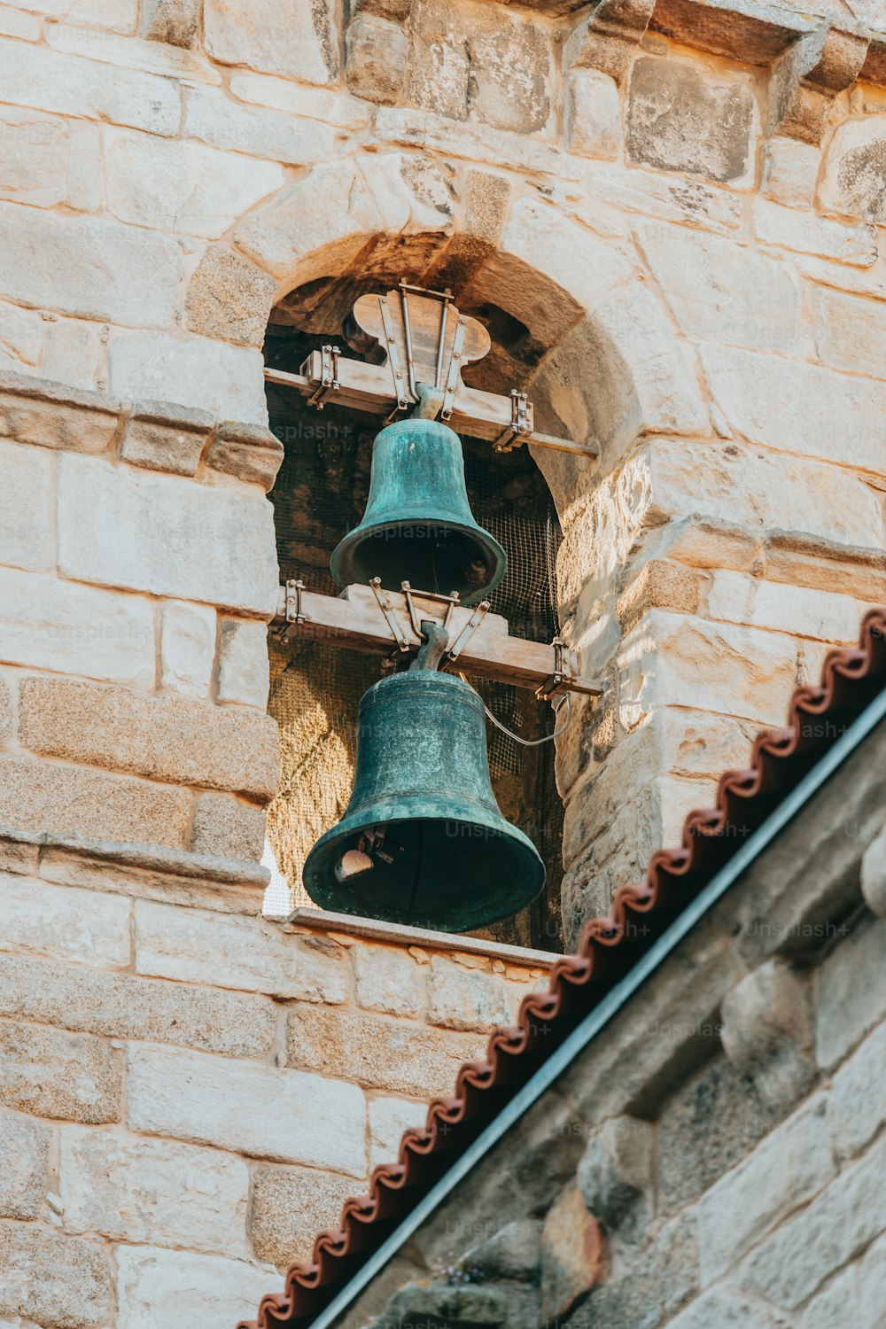 a couple of bells hanging from the side of a building