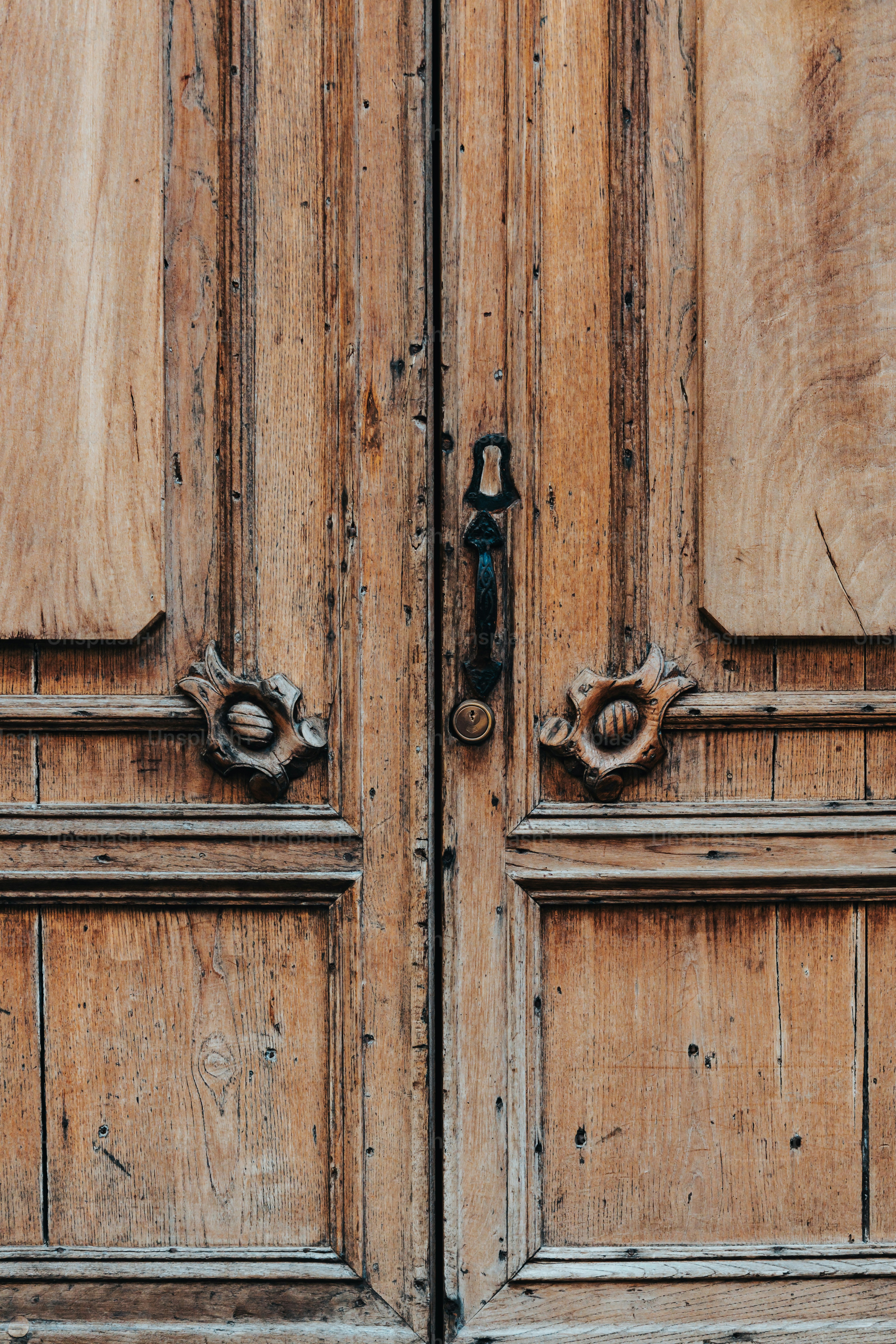 a close up of two wooden doors with metal handles