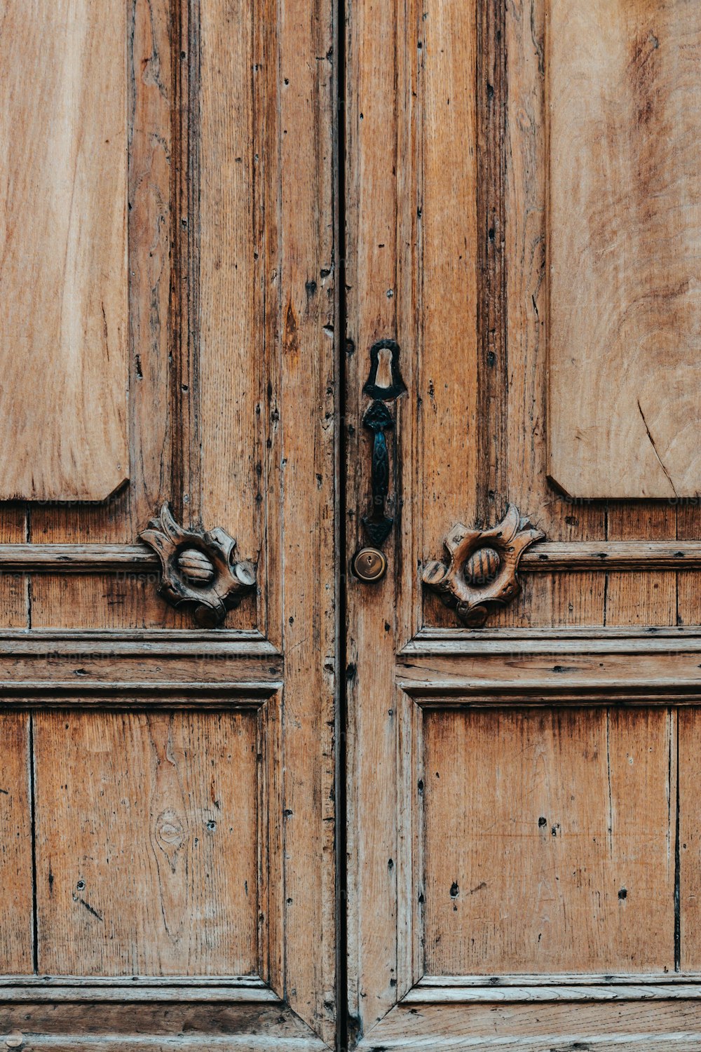 a close up of two wooden doors with metal handles