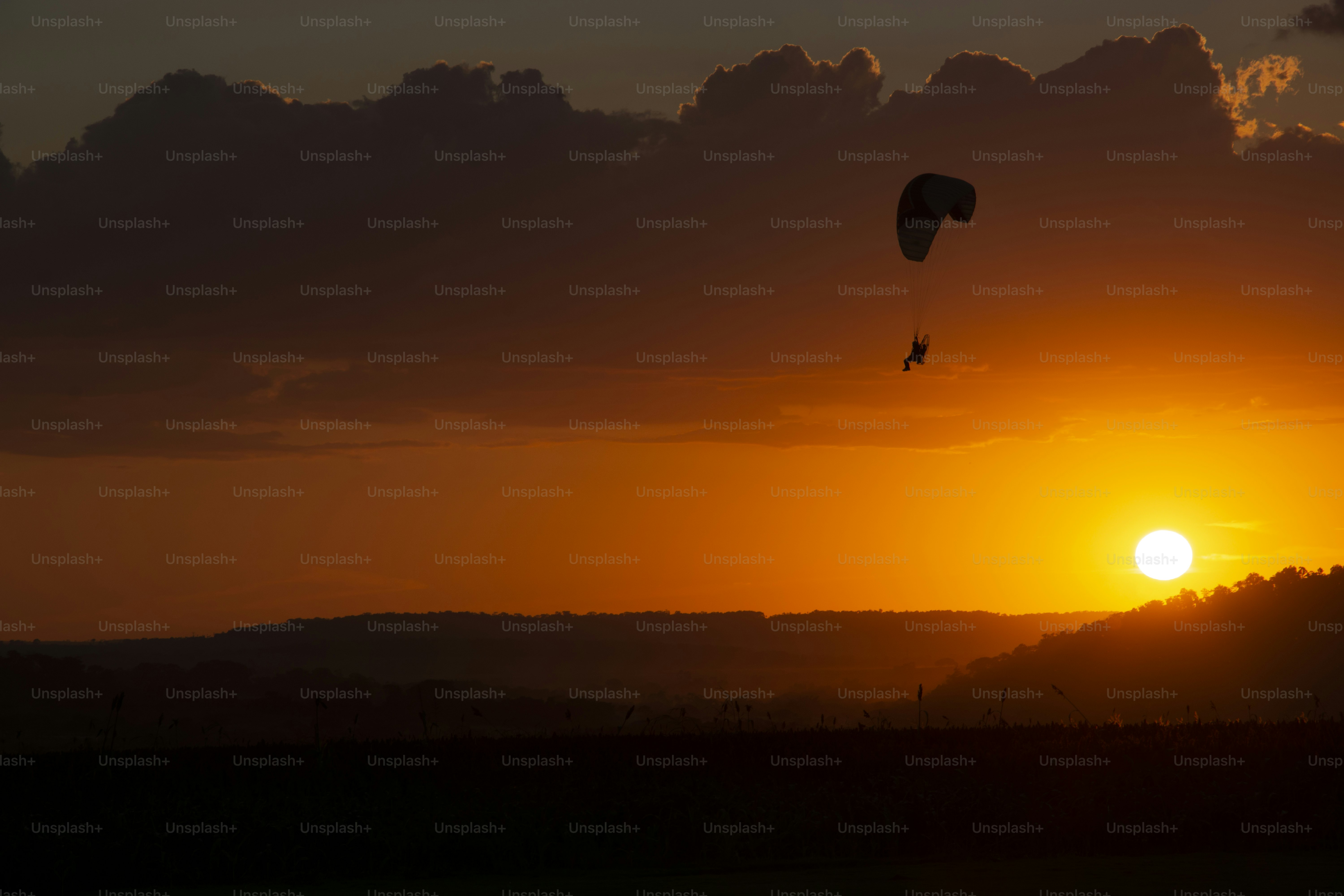 A couple of kites flying in the sky at sunset photo Backgrounds Image on Unsplash
