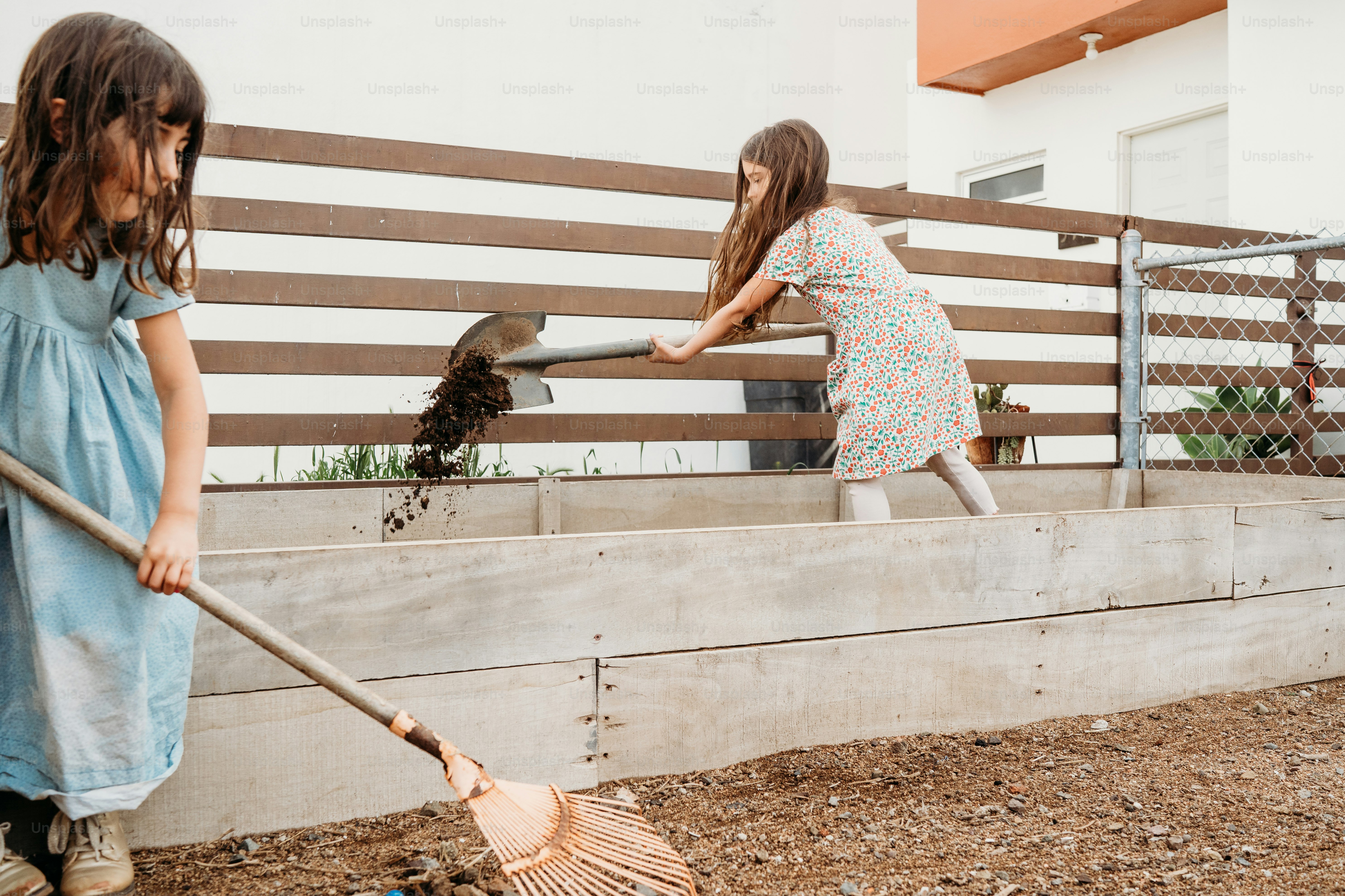 two little girls are playing with a broom