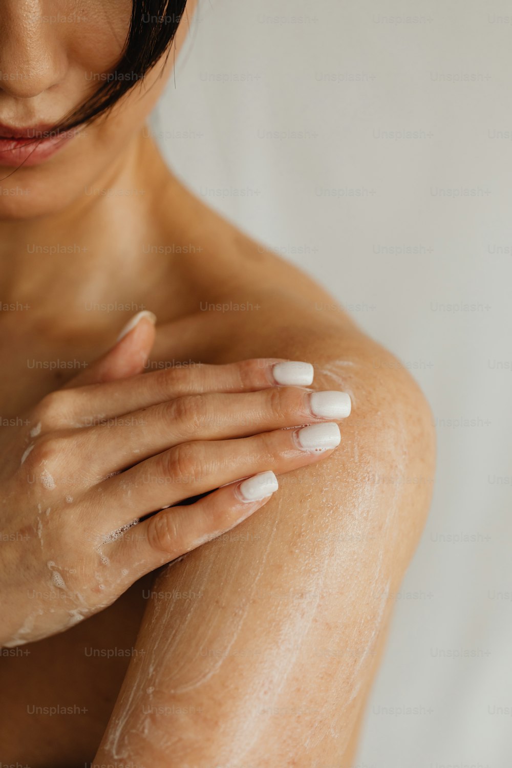 a woman with white nails and a white manicure on her arm