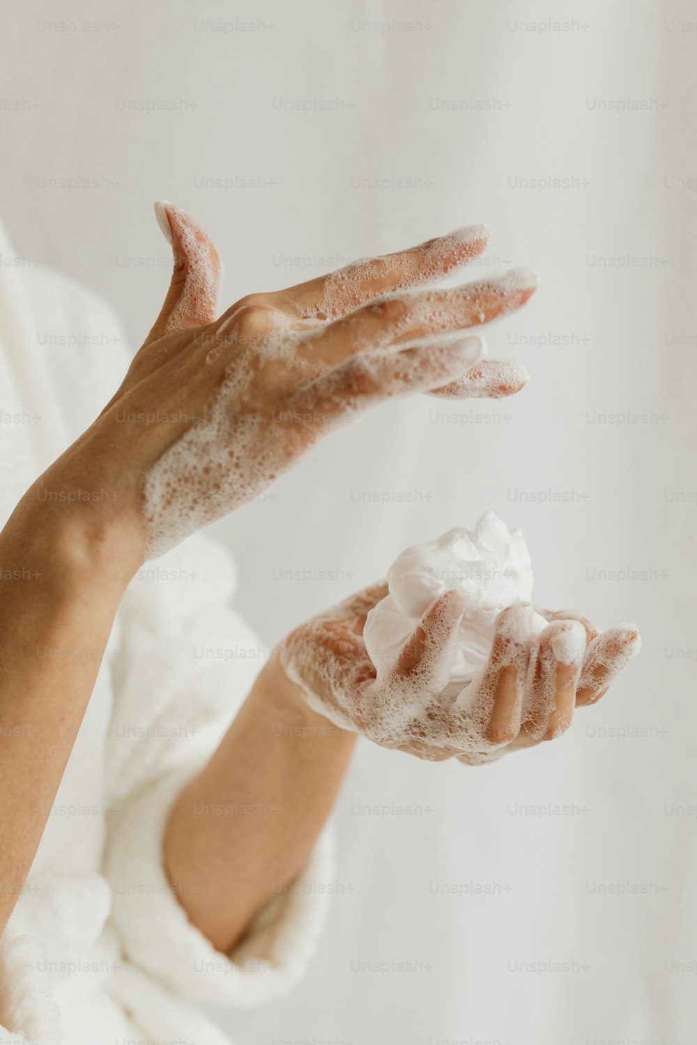 a woman is holding up her hands with a lot of soap on it