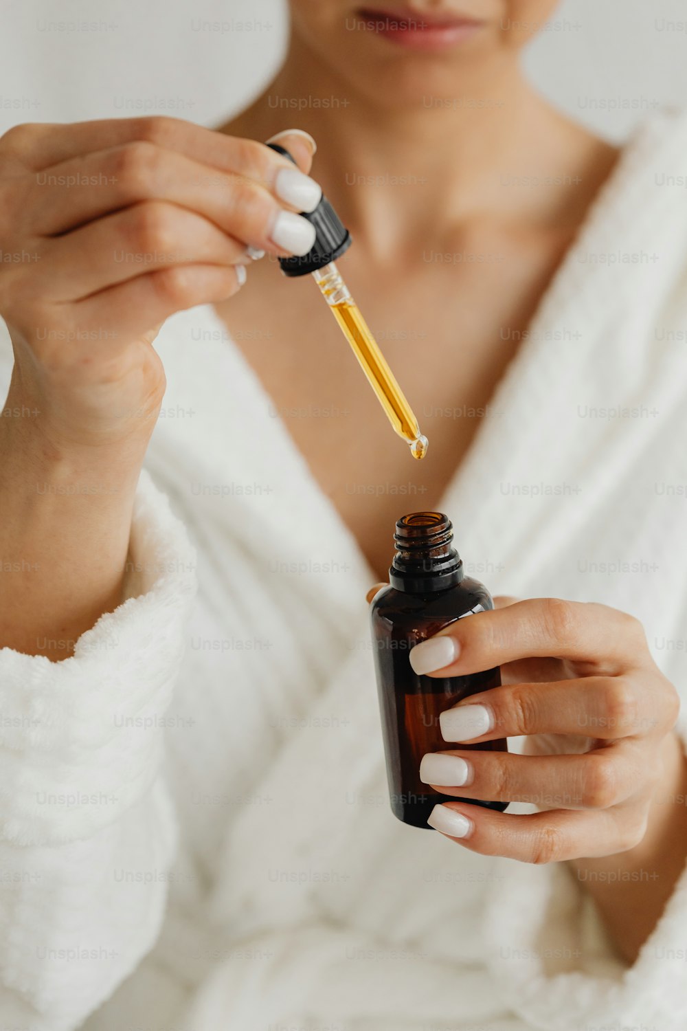 a woman holding a bottle of essential oils