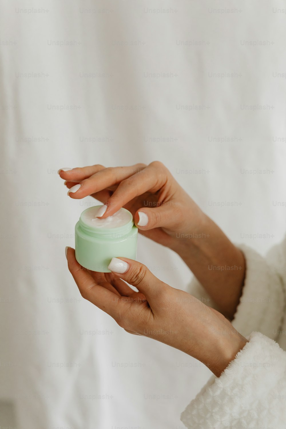 a woman holding a jar of cream in her hands