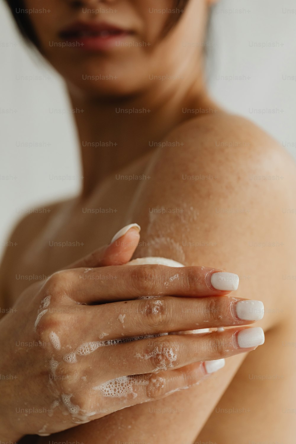 a woman holding her arm with a lot of soap on it