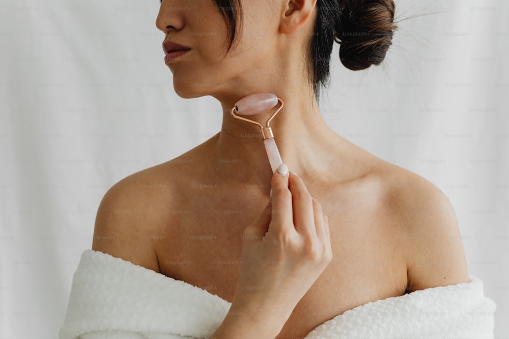 a woman in a white towel is holding a hair brush