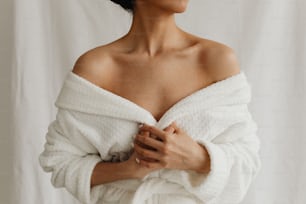 a woman wrapped in a white towel posing for a picture