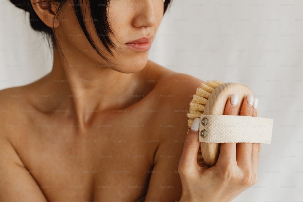 Una mujer sosteniendo un cepillo para el cabello en su mano derecha