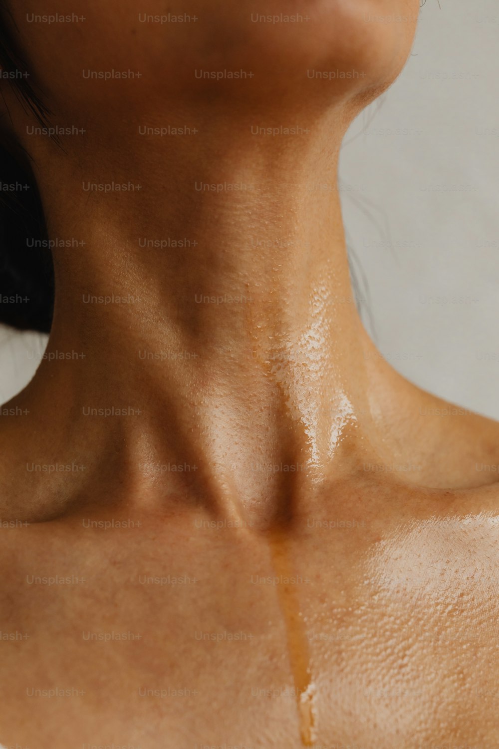 um close up do pescoço de uma mulher com muito óleo sobre ele