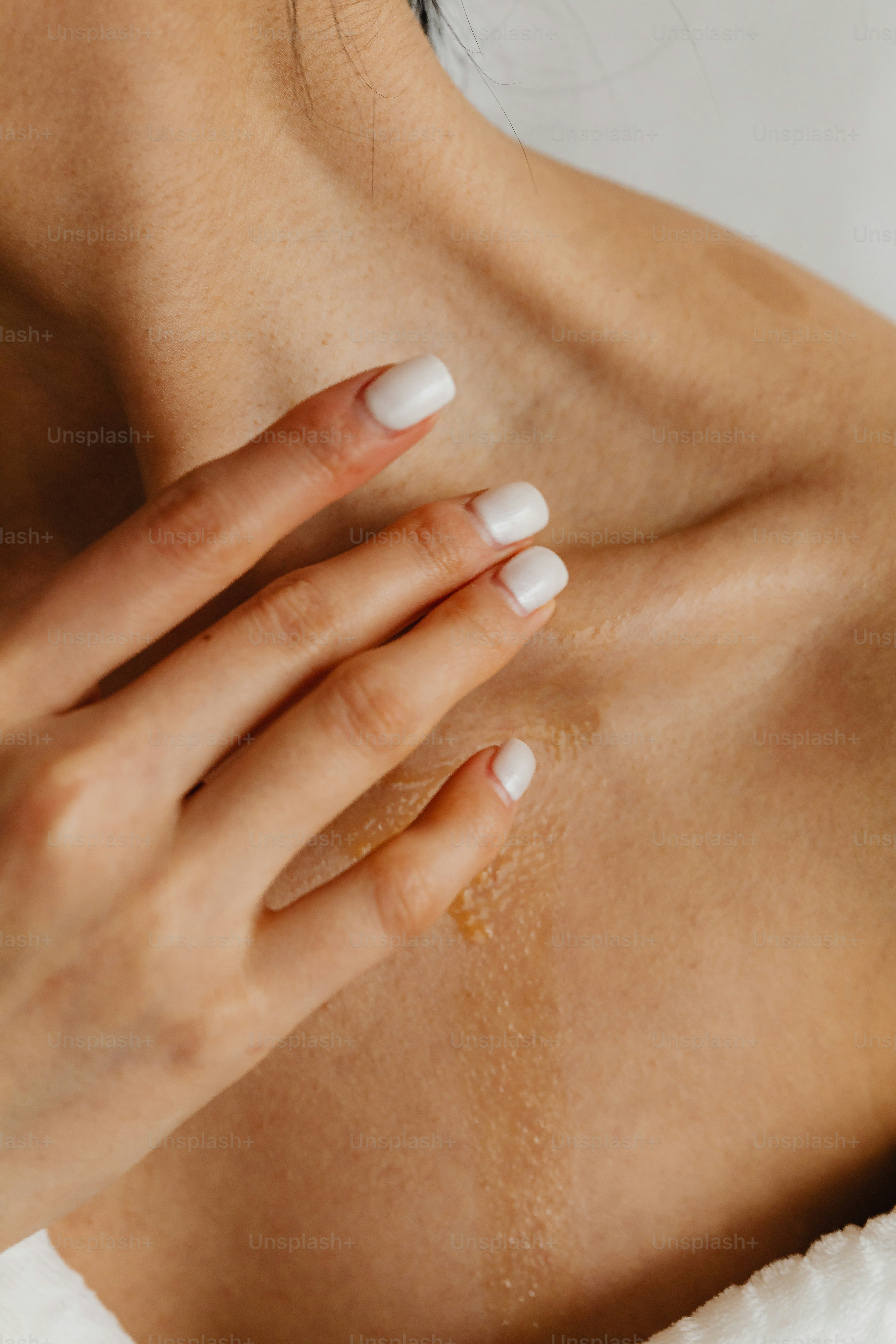 Un primer plano de la mano de una mujer con una manicura blanca en su