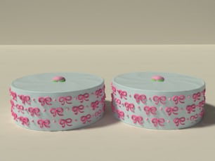 un par de cajas de pasteles con lazos rosas