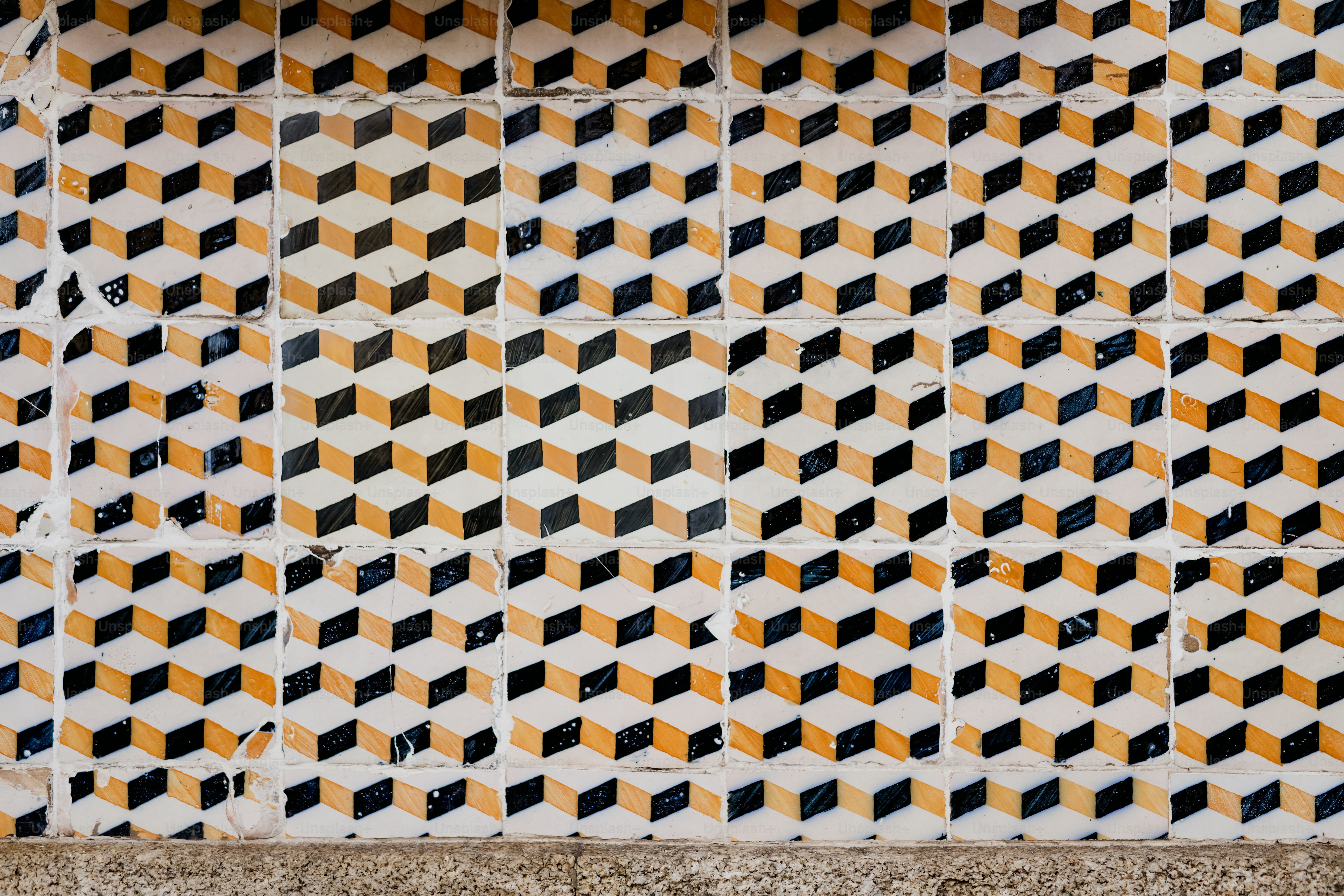 a close up of a tiled wall with yellow and black squares