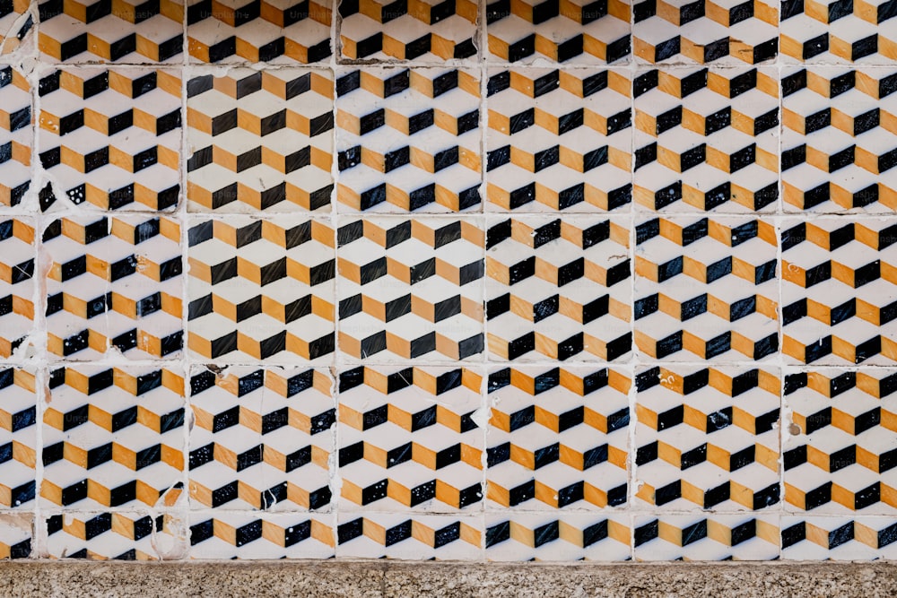 노란색과 검은색 사각형이 있는 타일 벽의 클로즈업
