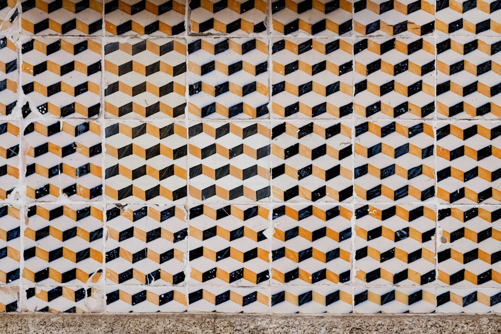 a close up of a tiled wall with yellow and black squares