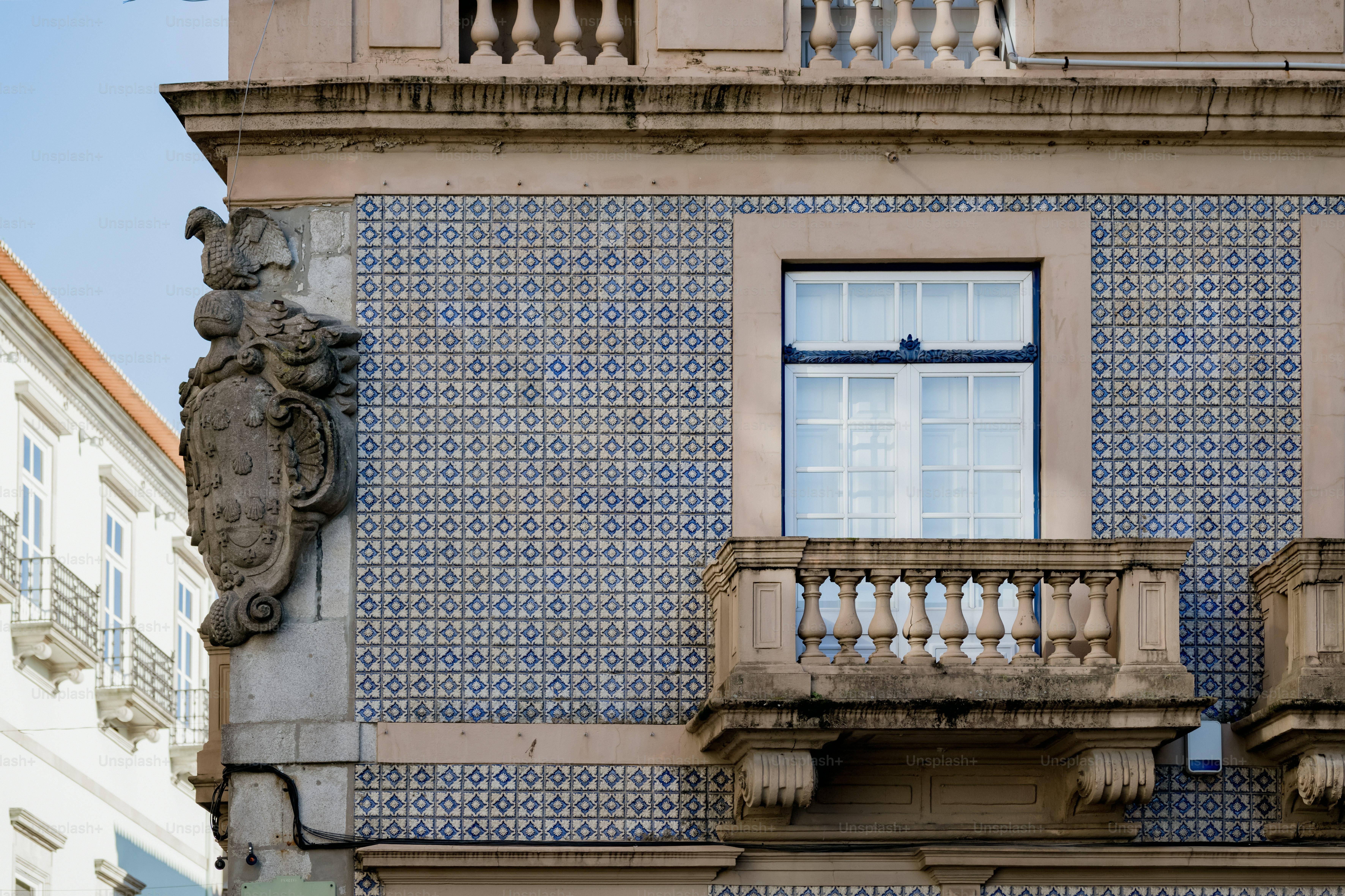 a blue and white building with a window and balcony