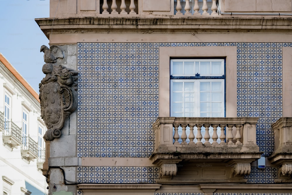 a blue and white building with a window and balcony