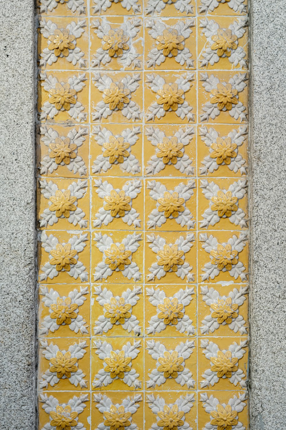 a yellow and white tile with white flowers on it