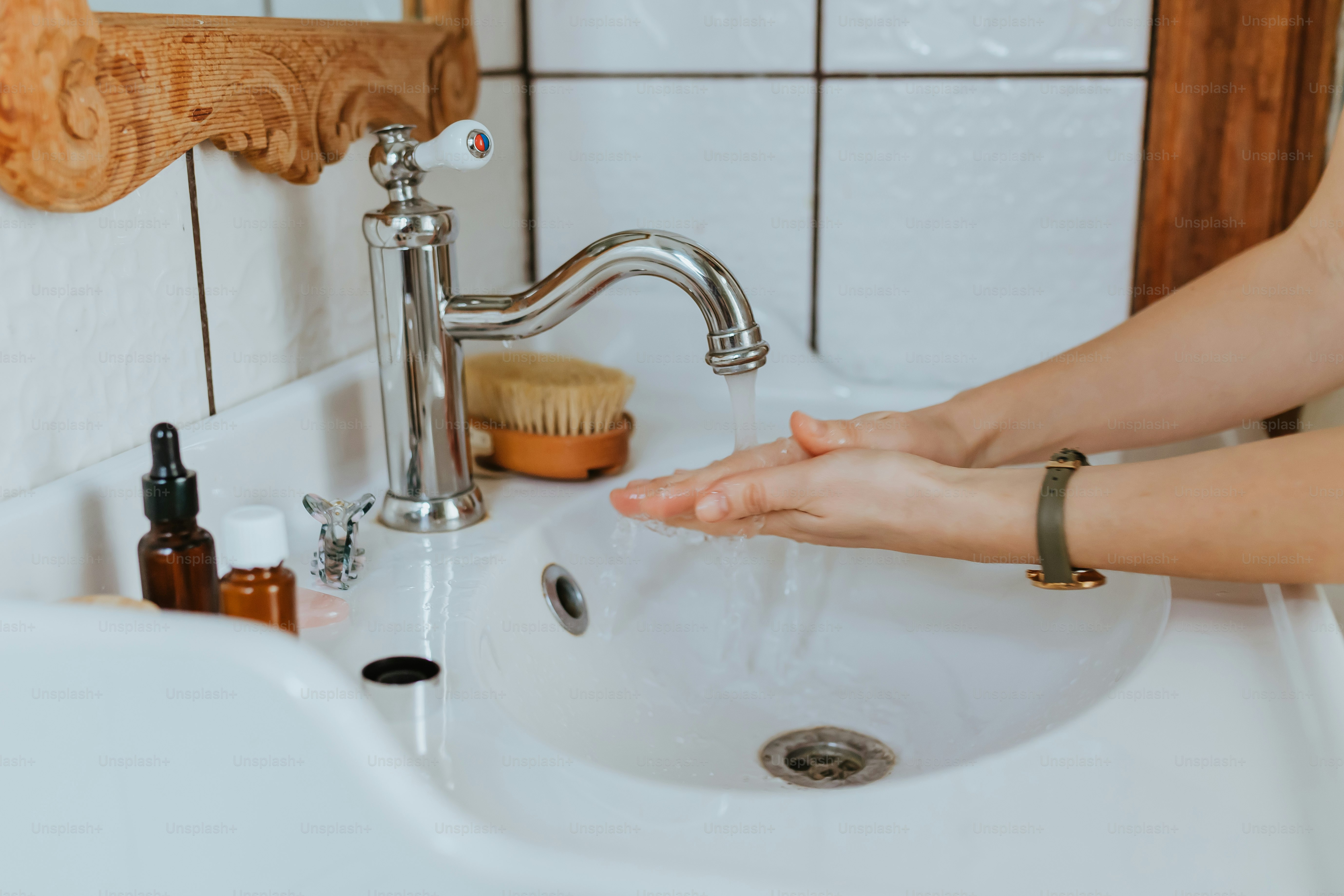Woman washing her hands at a bathroom sink during a personal hygiene routine