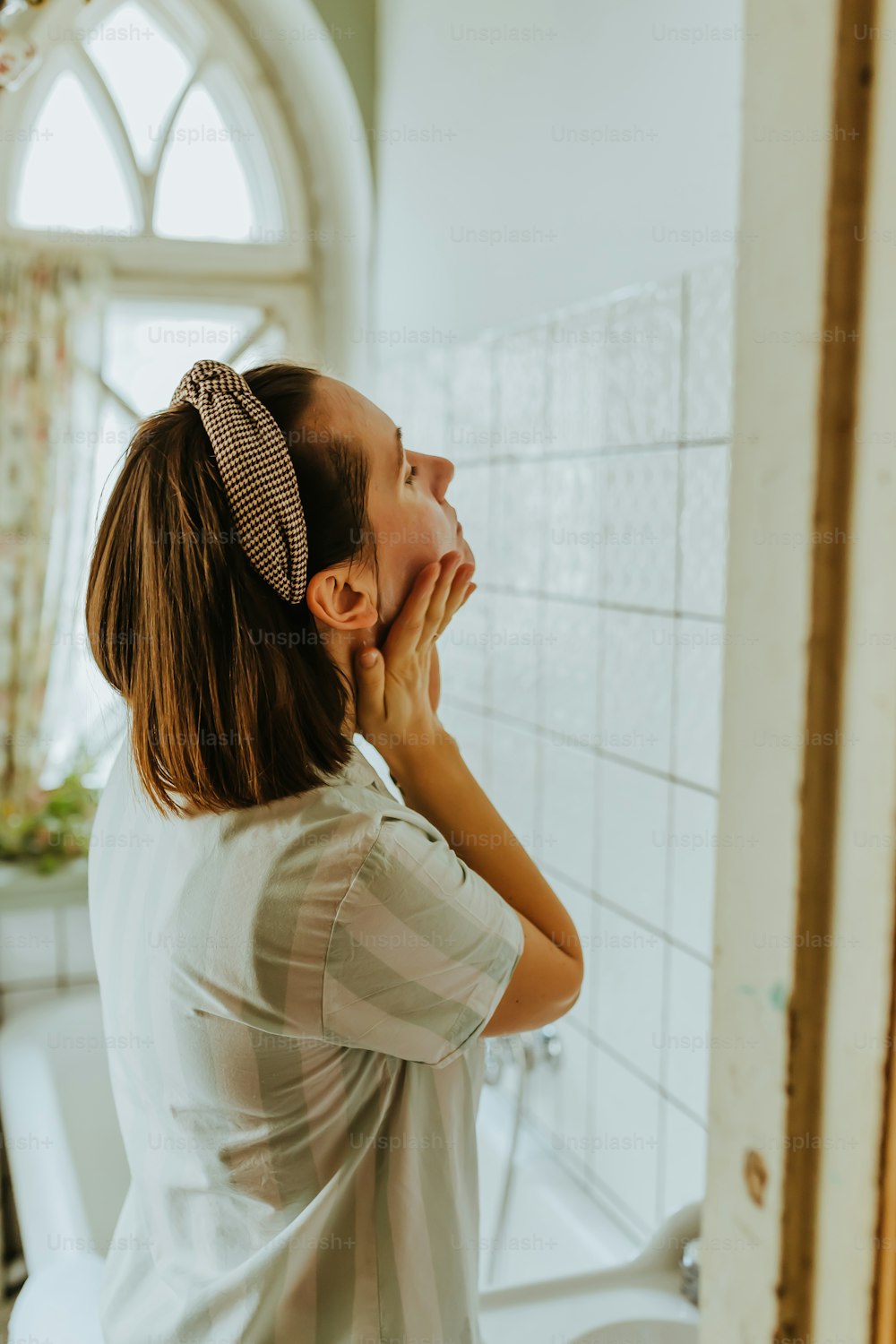Une femme debout devant un miroir de salle de bain