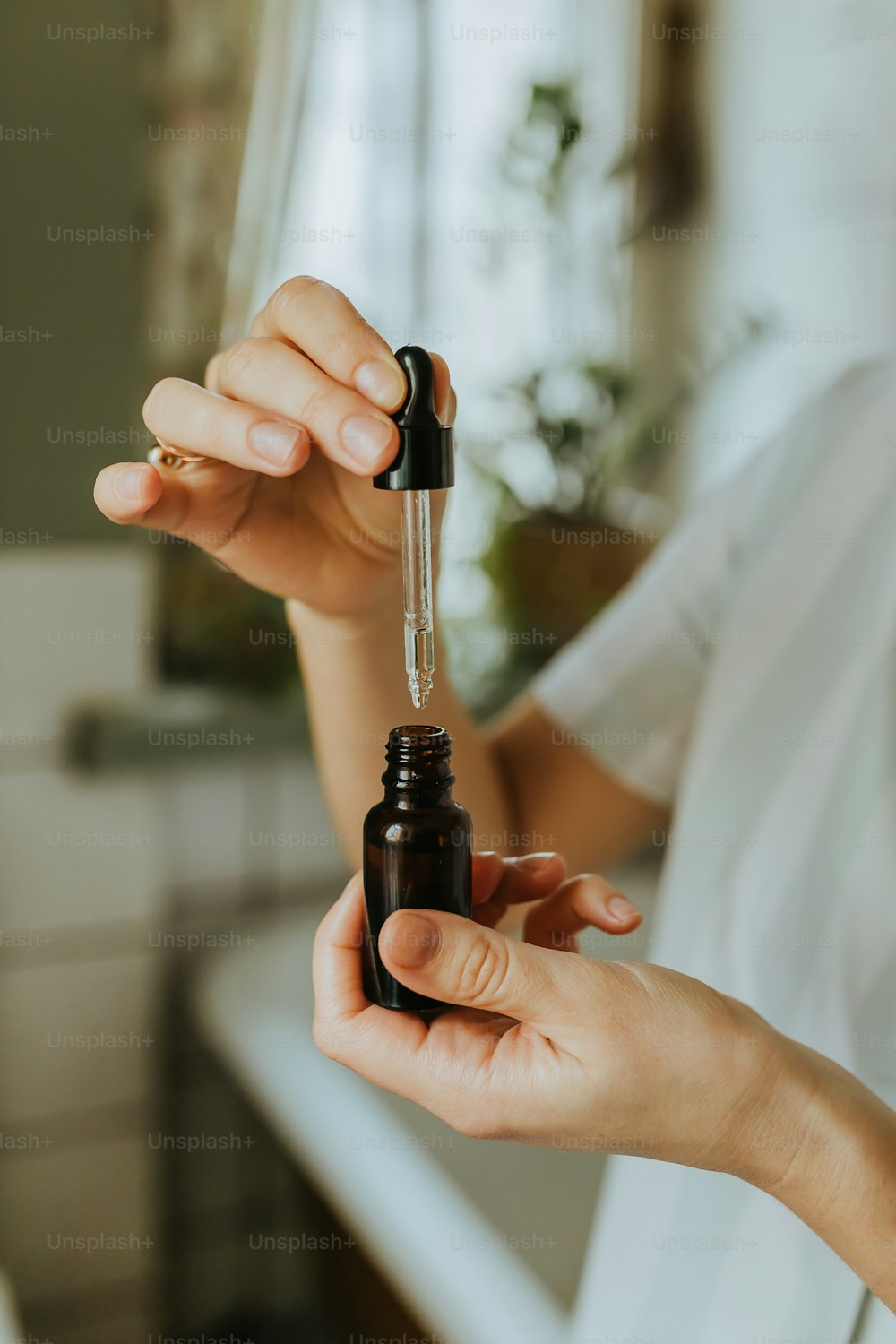 a person holding a bottle of essential oil