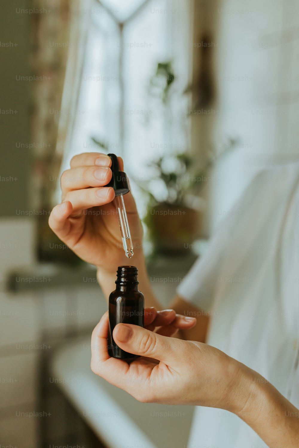 a woman is holding a bottle of essential oil