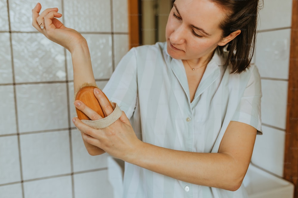 a woman in a white shirt is holding a jar of soap