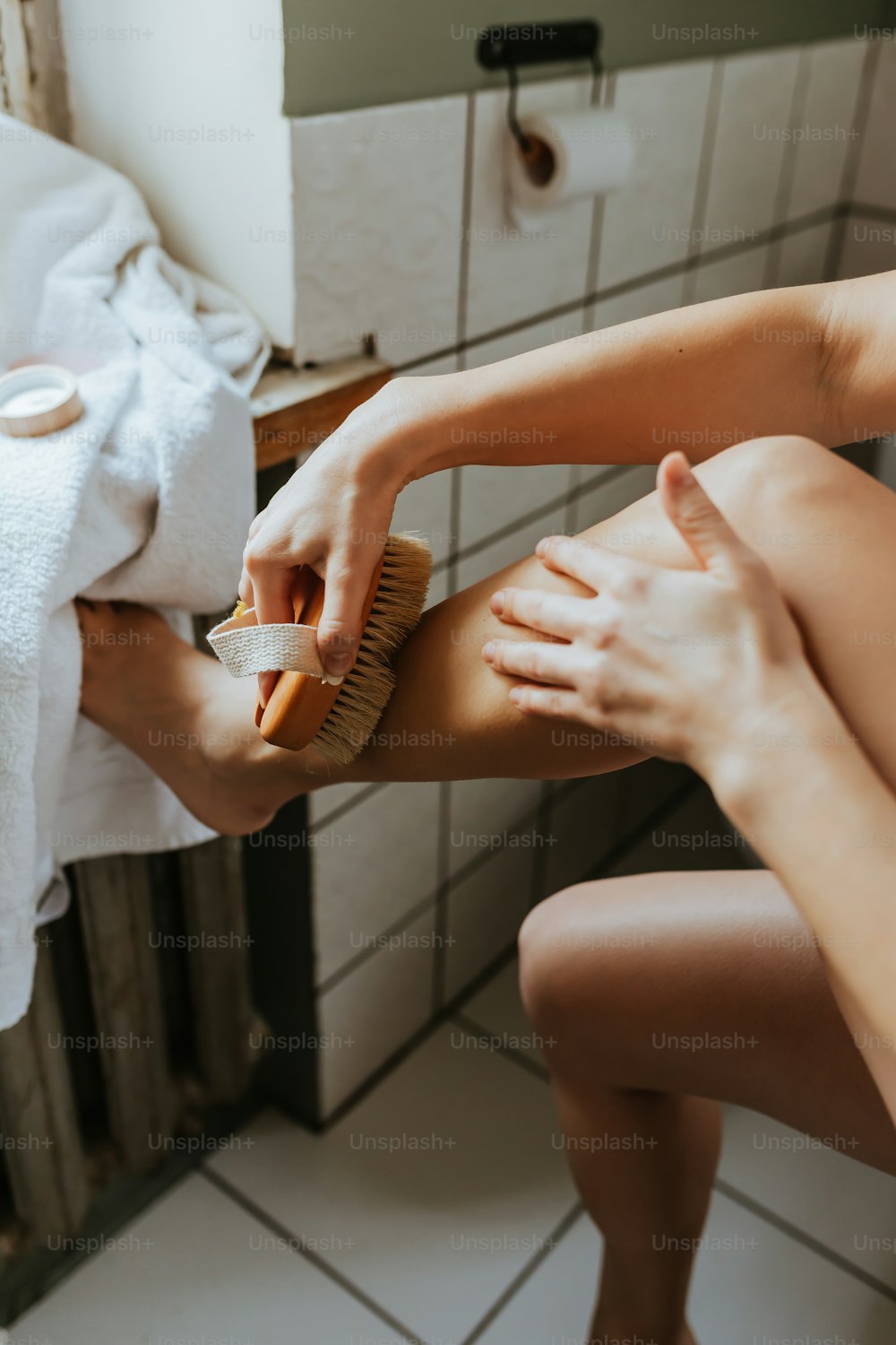 a woman is brushing her legs with a brush
