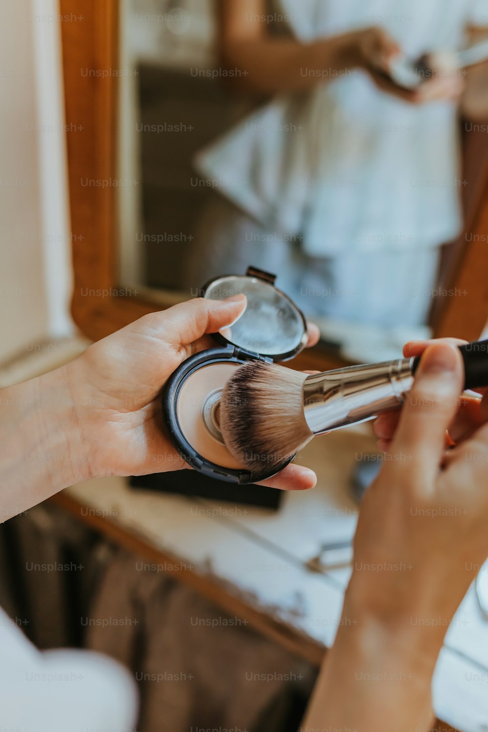 a woman is holding a brush and a mirror