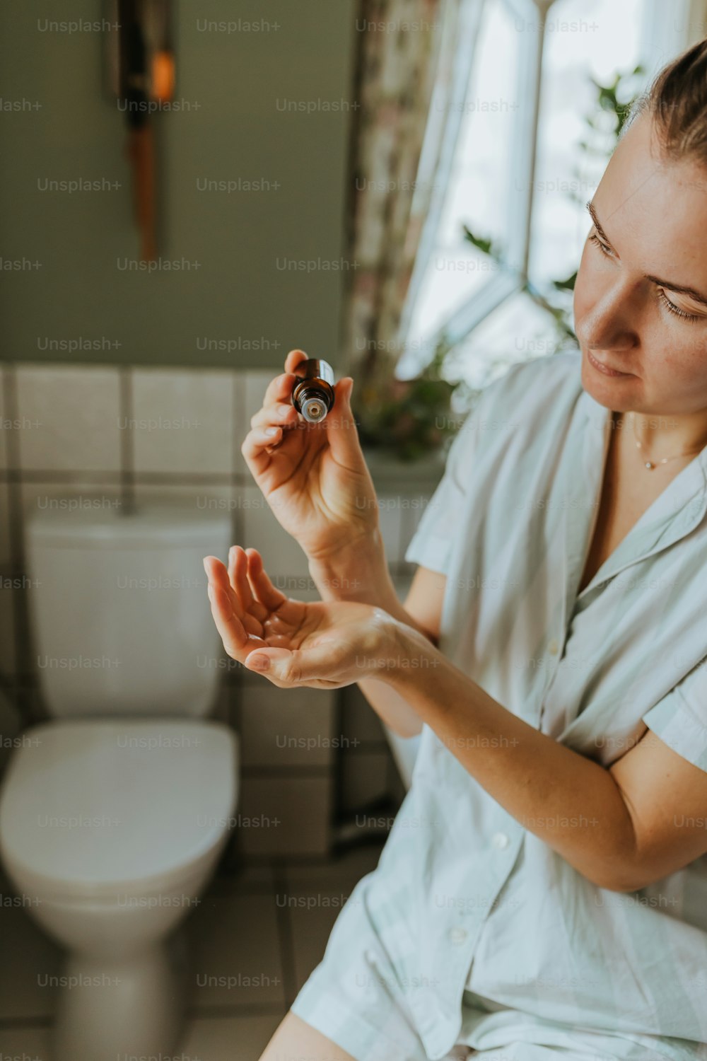Una mujer sentada en un inodoro sosteniendo un anillo