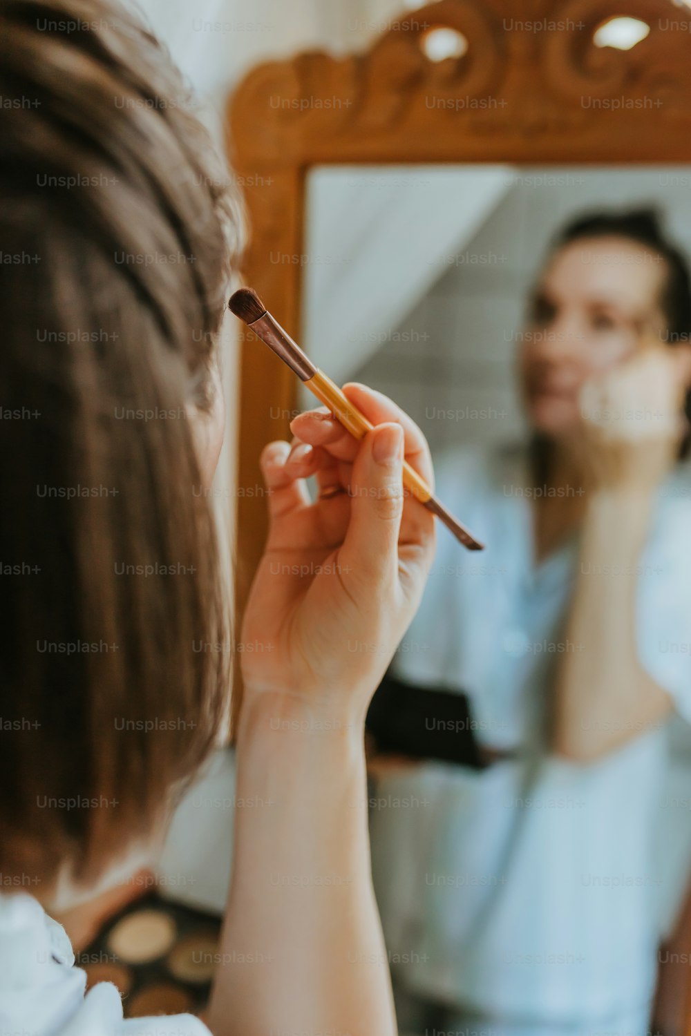 uma mulher escova os dentes na frente de um espelho