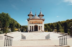 uma igreja com um campanário cercado por árvores