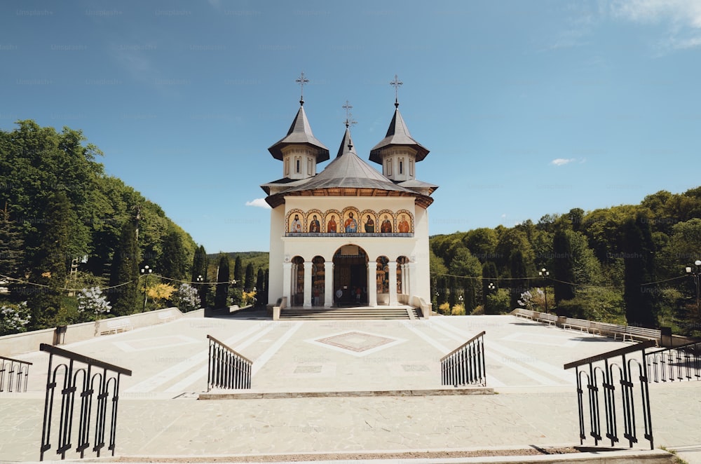 a church with a steeple surrounded by trees