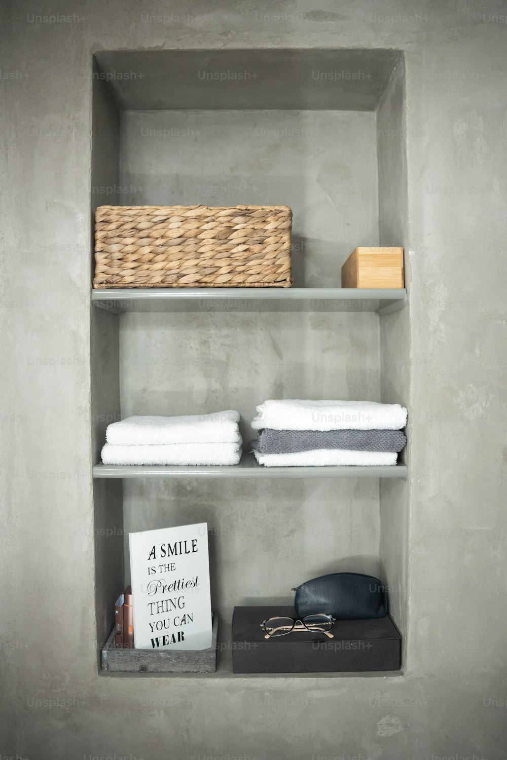 a shelf with towels and a basket on top of it