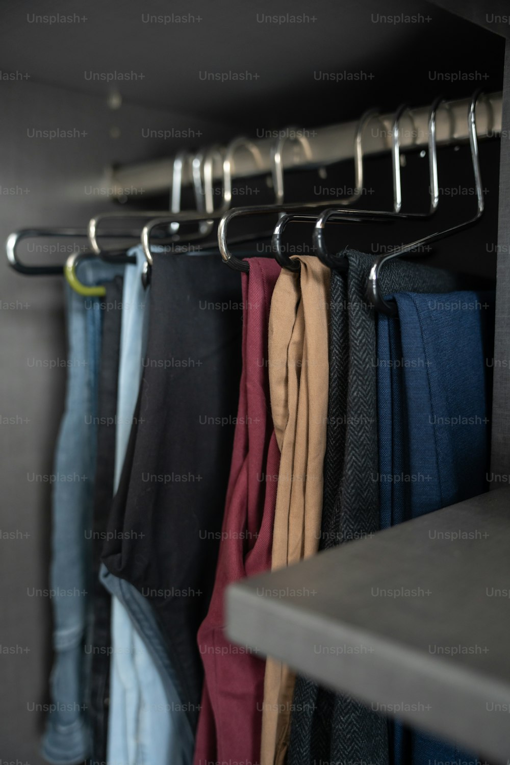 un estante de pantalones colgado en una pared