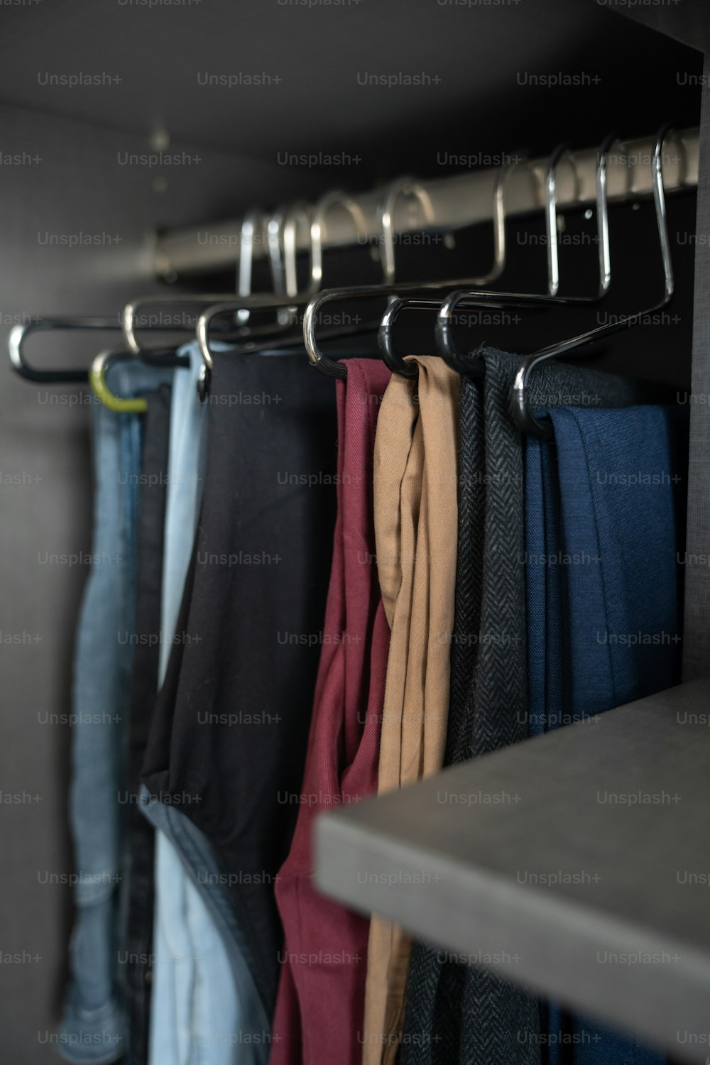 a rack of pants hanging on a wall