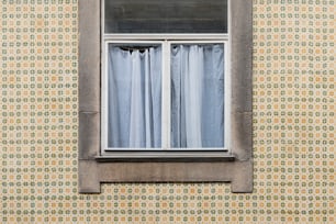 uma janela que tem uma cortina nela