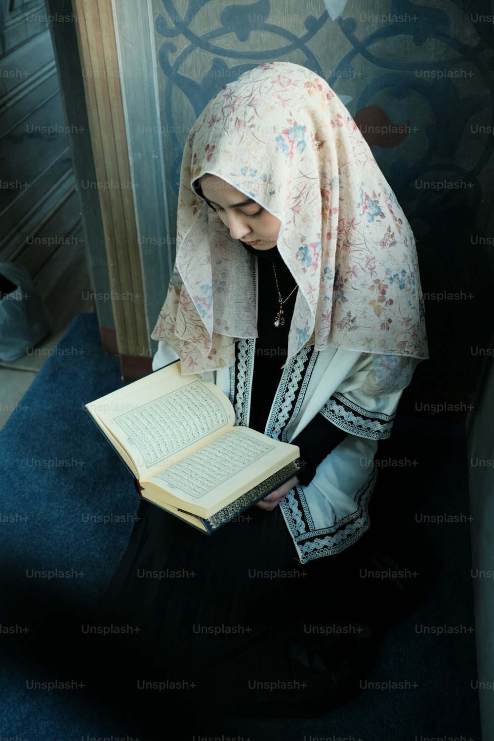 ヒジャーブを着た女性が本を読んでいる