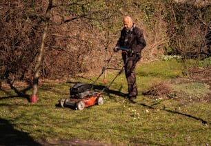 a man mowing the grass with a lawnmower