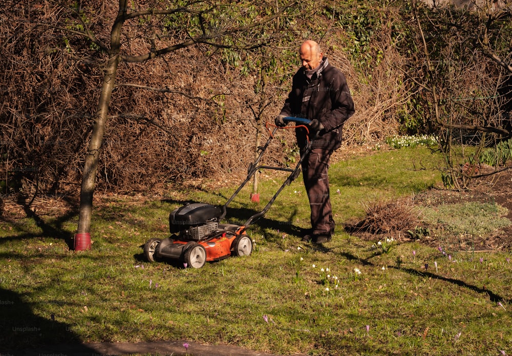 a man mowing the grass with a lawnmower