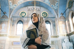 uma mulher usando um véu e segurando um livro