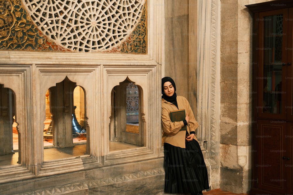 a woman standing in front of a building holding a book