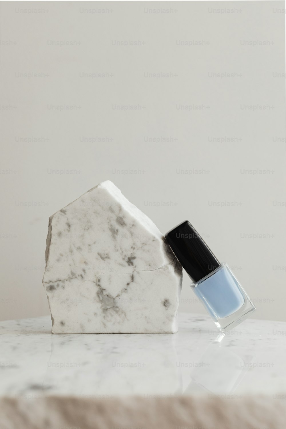 a bottle of nail polish sitting on top of a marble slab
