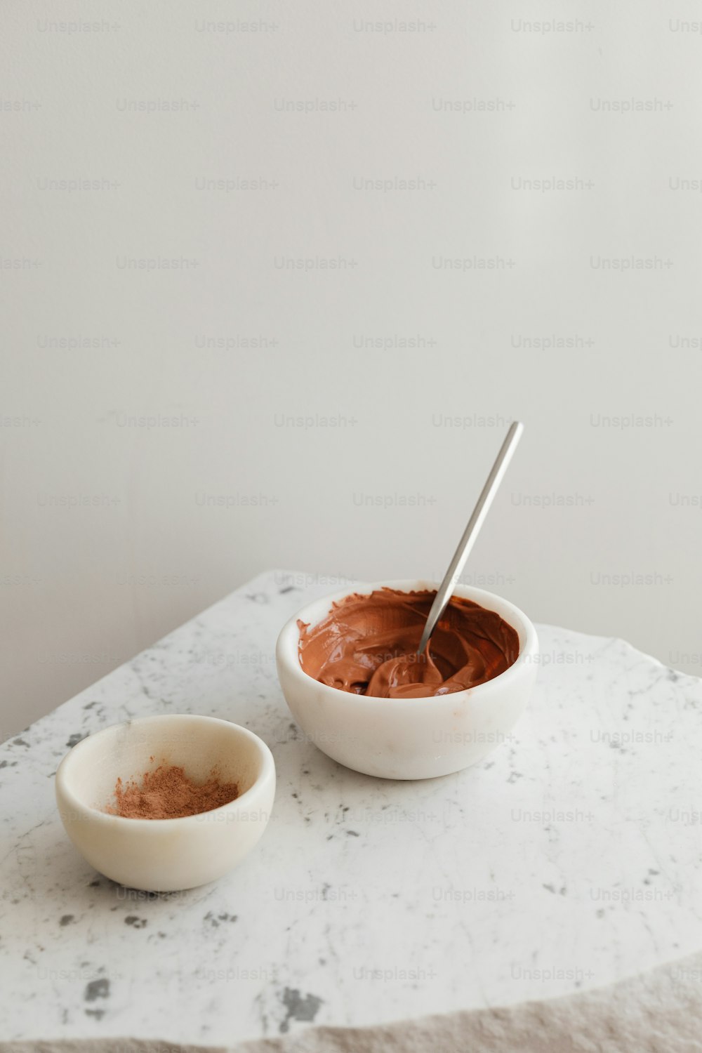 un bol de chocolat et un bol de poudre sur une table en marbre