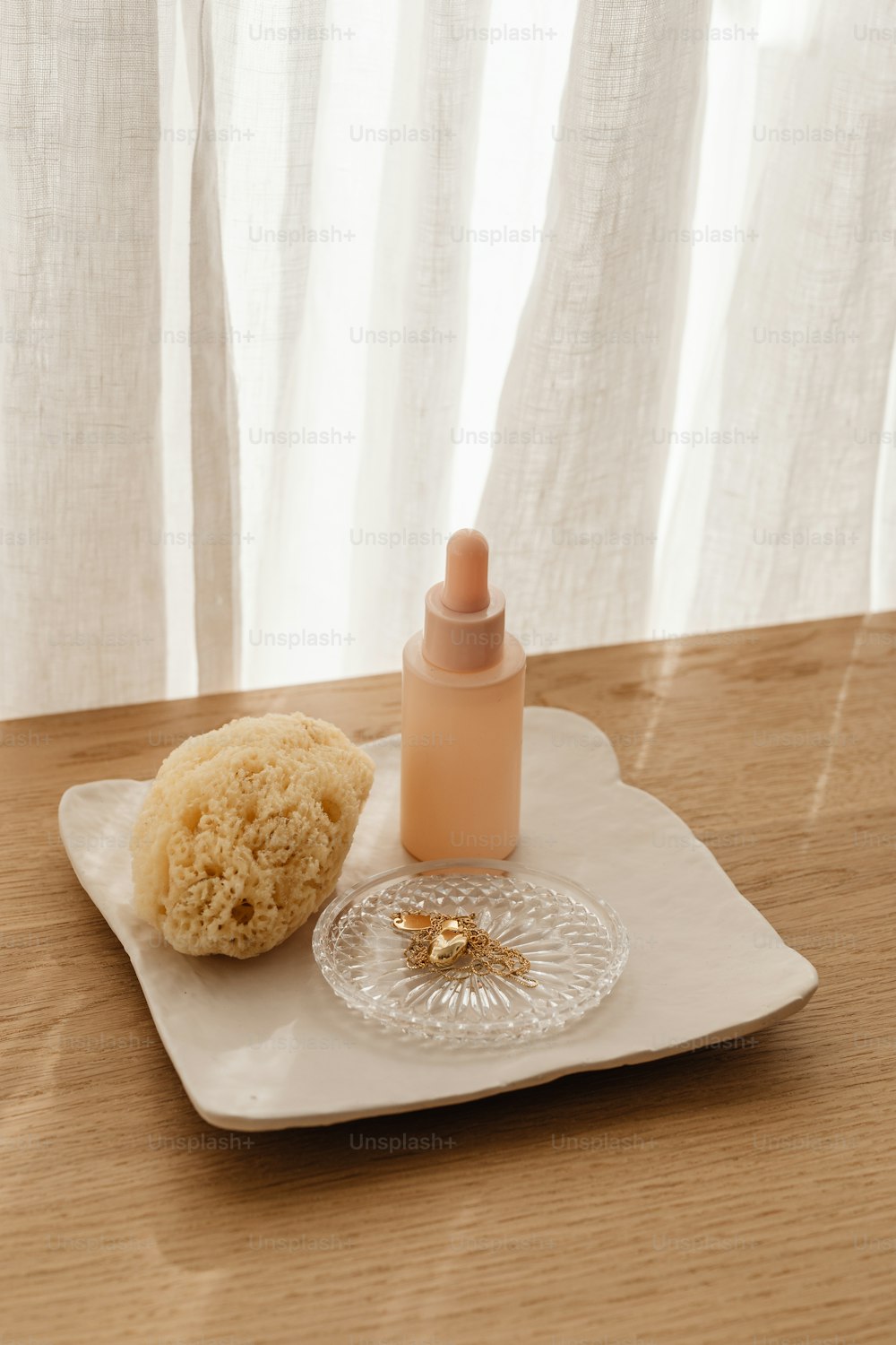 a white plate topped with a bottle of liquid next to a cookie